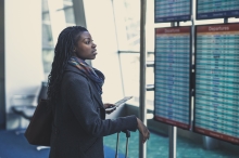 A woman looking at an airport's arrivals and departures board
